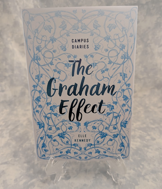 The book cover of 'The Graham Effect' by Elle Kennedy, part of the Campus Diaries series, displayed on a clear plastic stand against a textured gray background.