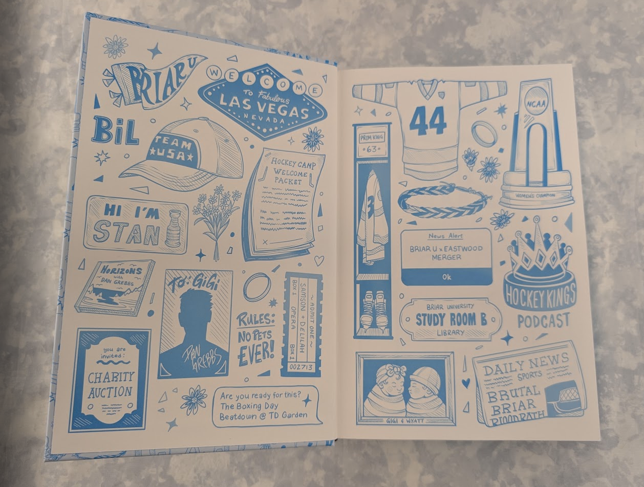 Hardcover endpapers featuring blue vintage-style illustrated labels, posters, and text elements on an off-white background, photographed on a mottled light gray surface.