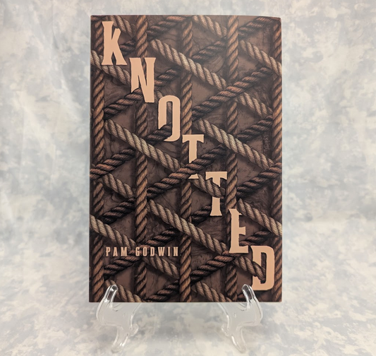 The book cover of 'Knotted' by Pam Godwin, displayed upright on a clear plastic stand against a textured gray background. The cover features a dark brown background with a woven rope pattern and the title 'KNOTTED' written horizontally in a light beige serif font.